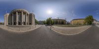 an image of a 360 - view panoramic image of a roundabout with two buildings and trees in front