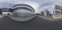 a very big building with a big curve like roof and some sky in the background