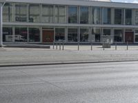 an empty street in front of a store called big b on the corner of a road