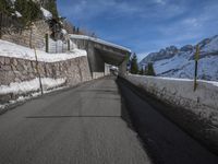 an empty road with snow and mountains in the background on a clear day on the mountain side