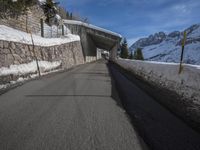 an empty road with snow and mountains in the background on a clear day on the mountain side