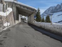 an empty road with snow and mountains in the background on a clear day on the mountain side