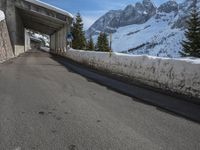 an empty road with snow and mountains in the background on a clear day on the mountain side