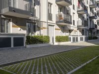 an apartment complex with lawn and sidewalk walkways, with an enclosed courtyard and many apartments