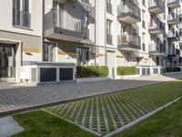 an apartment complex with lawn and sidewalk walkways, with an enclosed courtyard and many apartments