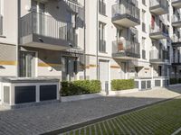 an apartment complex with lawn and sidewalk walkways, with an enclosed courtyard and many apartments