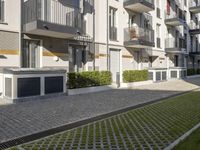 an apartment complex with lawn and sidewalk walkways, with an enclosed courtyard and many apartments