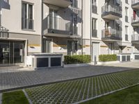 an apartment complex with lawn and sidewalk walkways, with an enclosed courtyard and many apartments