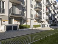 an apartment complex with lawn and sidewalk walkways, with an enclosed courtyard and many apartments