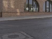 a car parked along the side of a building next to a sidewalk and water fountain