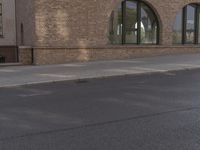 a car parked along the side of a building next to a sidewalk and water fountain