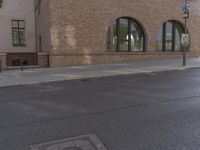 a car parked along the side of a building next to a sidewalk and water fountain