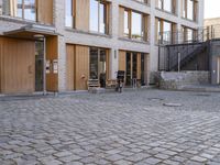 the building is made of wood and has windows on all the sides of it the bicycles are standing outside