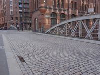 there is a brick floor with a bridge on the sidewalk in front of the building