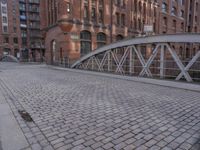 there is a brick floor with a bridge on the sidewalk in front of the building