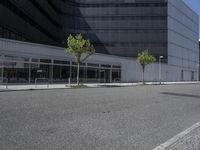 a sidewalk on a clear day with buildings and trees along side of road on either side