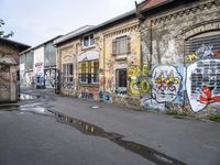 the road that leads to the two buildings is covered by street art and some colorful graffiti