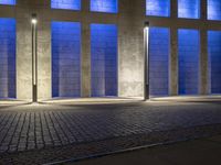 a building with some very tall windows and light in them at night time lite up with blue lights