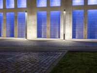a building with some very tall windows and light in them at night time lite up with blue lights