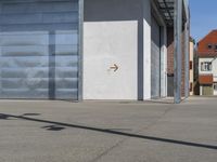 a large parking garage in front of a building with two arrows on it and a metal ramp