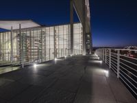 outside area of building with windows and light fixtures lit up at night by stairs and stairs