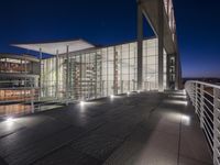 outside area of building with windows and light fixtures lit up at night by stairs and stairs