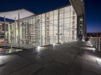 outside area of building with windows and light fixtures lit up at night by stairs and stairs