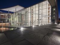 outside area of building with windows and light fixtures lit up at night by stairs and stairs