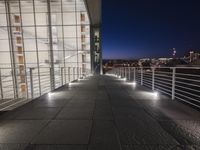outside area of building with windows and light fixtures lit up at night by stairs and stairs