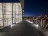 outside area of building with windows and light fixtures lit up at night by stairs and stairs