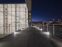 outside area of building with windows and light fixtures lit up at night by stairs and stairs
