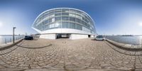 a 360 - ray view of a modern building near the water of a river in germany