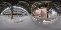 a reflection of a train station across the tracks from another building, taken in a fisheye lens