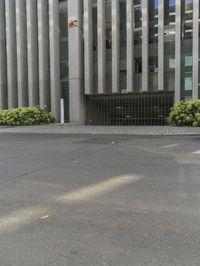 a person with a backpack standing by the curb outside the building in front of the street