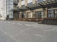 an empty building with signs on the street and people on bikes in traffic passing by