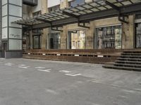 an empty building with signs on the street and people on bikes in traffic passing by