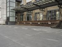 an empty building with signs on the street and people on bikes in traffic passing by