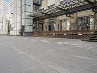 an empty building with signs on the street and people on bikes in traffic passing by