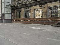 an empty building with signs on the street and people on bikes in traffic passing by