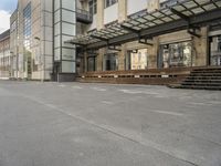 an empty building with signs on the street and people on bikes in traffic passing by