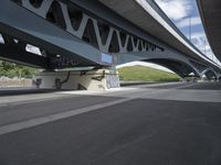 a bike is riding under a bridge over a road with graffiti and a person in a wet suit