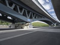 a bike is riding under a bridge over a road with graffiti and a person in a wet suit