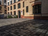 a sidewalk with chairs next to the brick building on the side, some have stairs and some buildings in the background