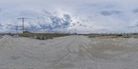 a panorama fisheye view of a beach with an open area in the background and an island