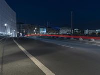 large building on the street with lights in front and other buildings nearby at night with no one moving