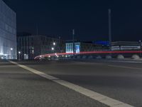 large building on the street with lights in front and other buildings nearby at night with no one moving