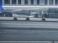 the empty city road is empty by the tall building in the background at night with light streaking on the buildings