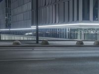 the empty city road is empty by the tall building in the background at night with light streaking on the buildings