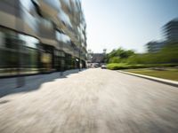 a car driving on a city street with trees and buildings behind it on a sunny day