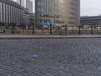 the sidewalk has a little blue can laying on it's side, and a blue plastic ball in front of it